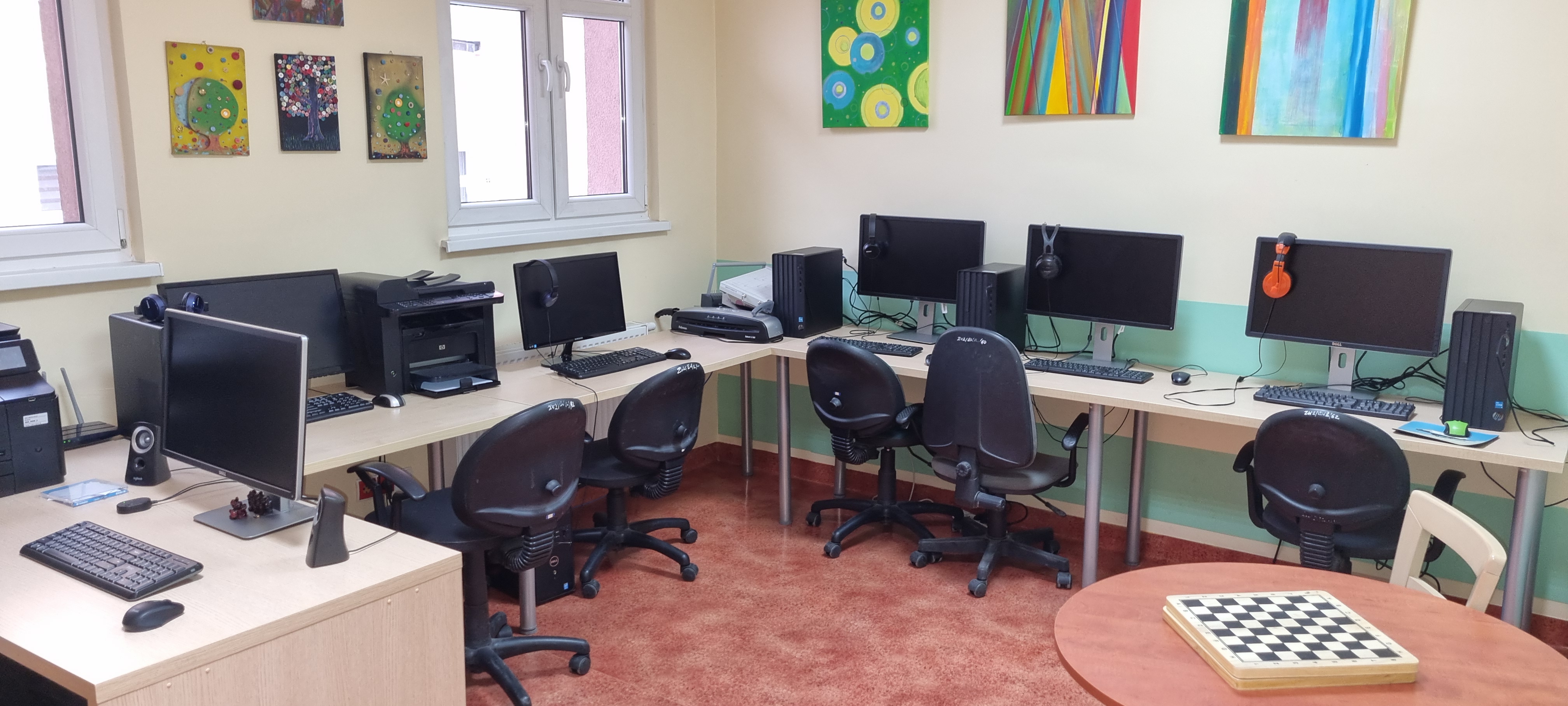 Pomieszczenie biurowe z krzesłami i biurkiem.