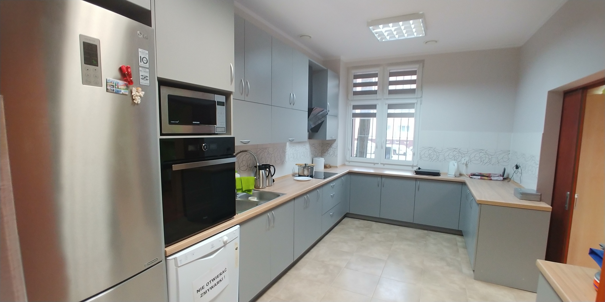 Pomieszczenie kuchenne z szafkami i sprzętem AGD.