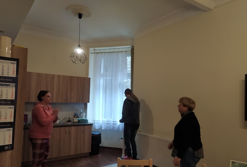 Trzy kobiety wykonują ćwiczenia w salonie chodząc i podrzucając piłeczką.