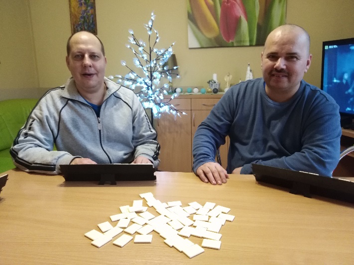 Dwóch mężczyzn siedzących przy stole i grających w grę.