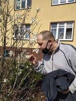 Mężczyzna wąchający kwiat magnolii. 