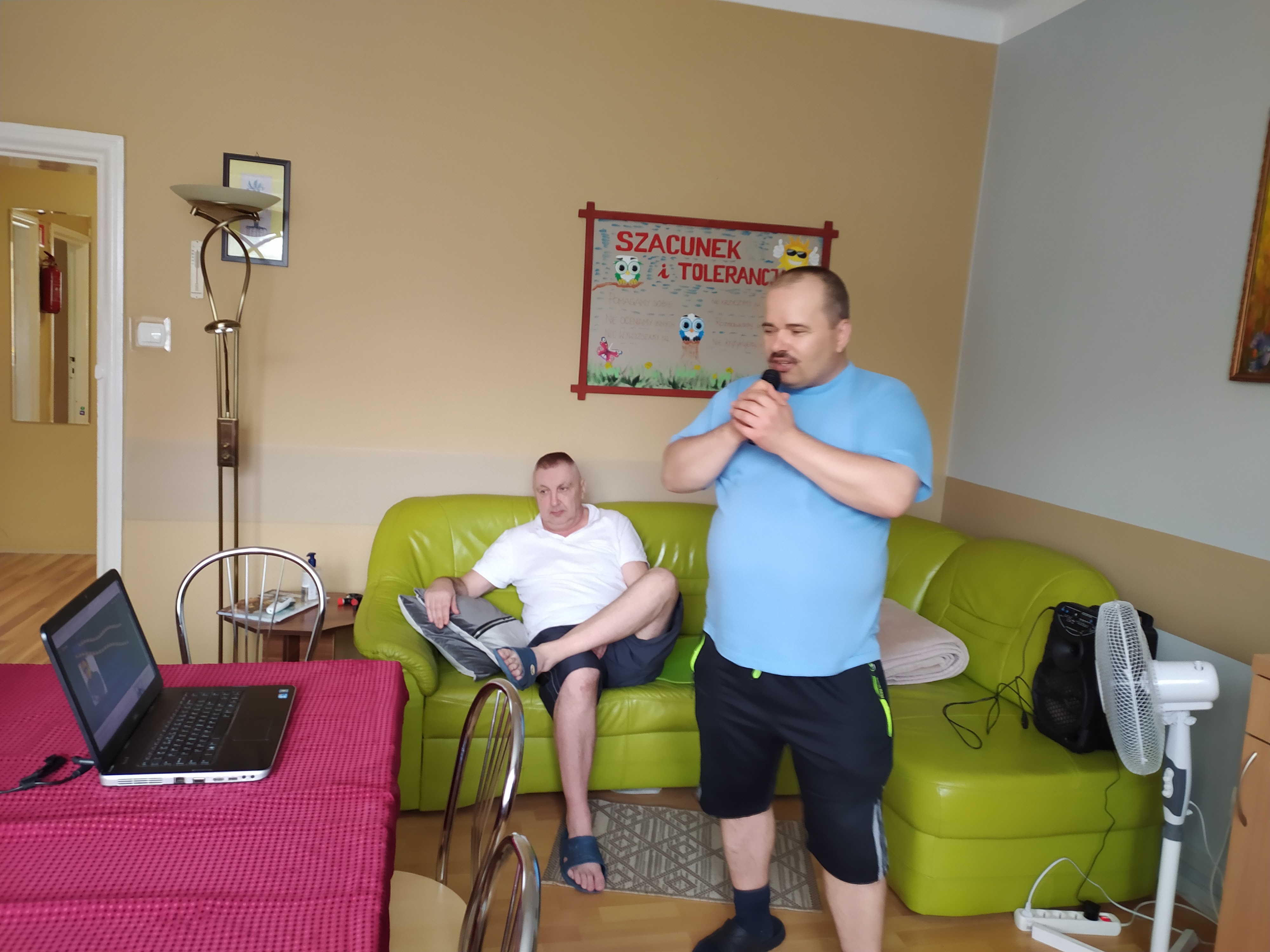 Mężczyzna z mikrofonem śpiewa piosenkę.