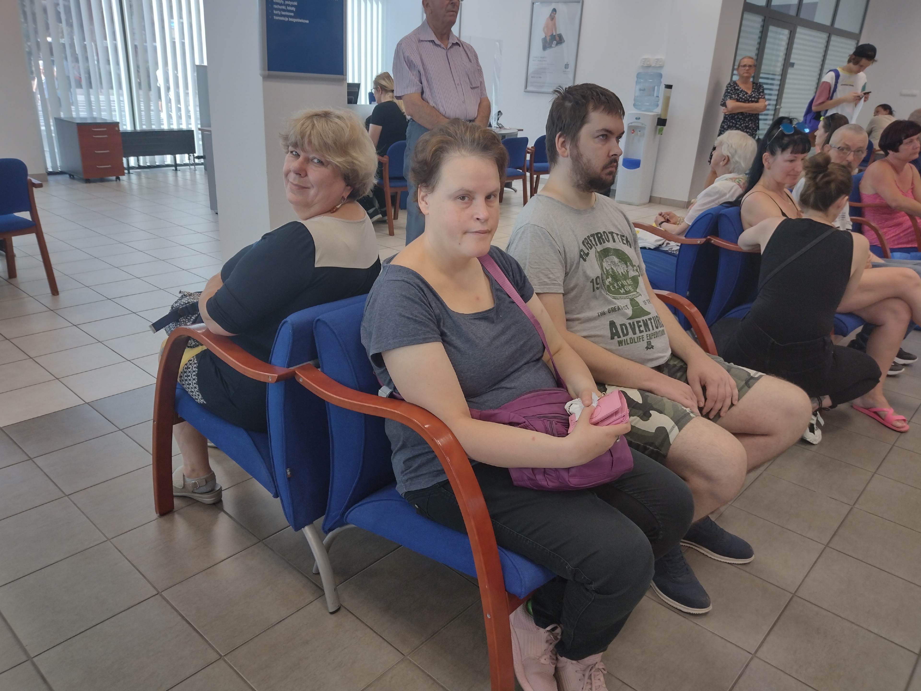 Mieszkanka i opiekun mieszkania siedzą przed okienkiem w banku. 