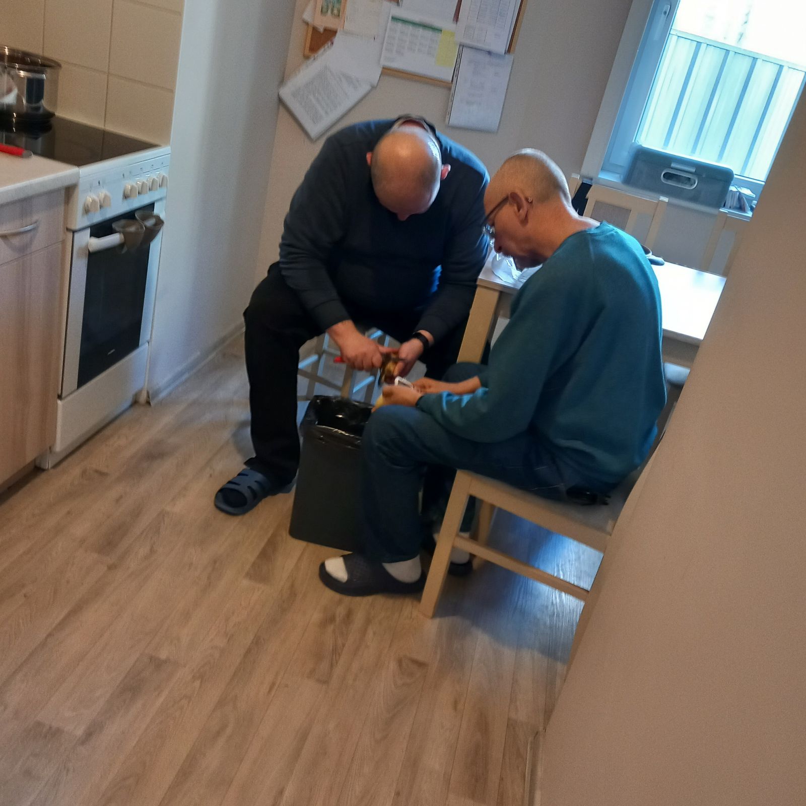 Dwaj mężczyźni obierają ziemniaki.