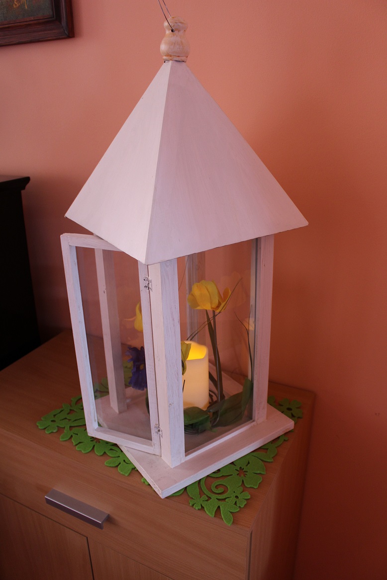 Duży lampion drewnainy pomalowany na biało.