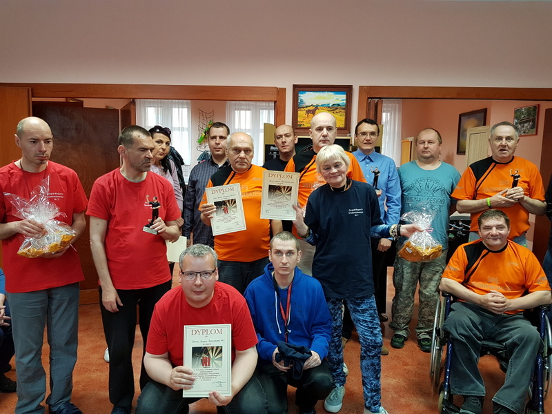 2 kobiety i 12 mężczyzn trzymający w ręku  dyplomy i nagrody.