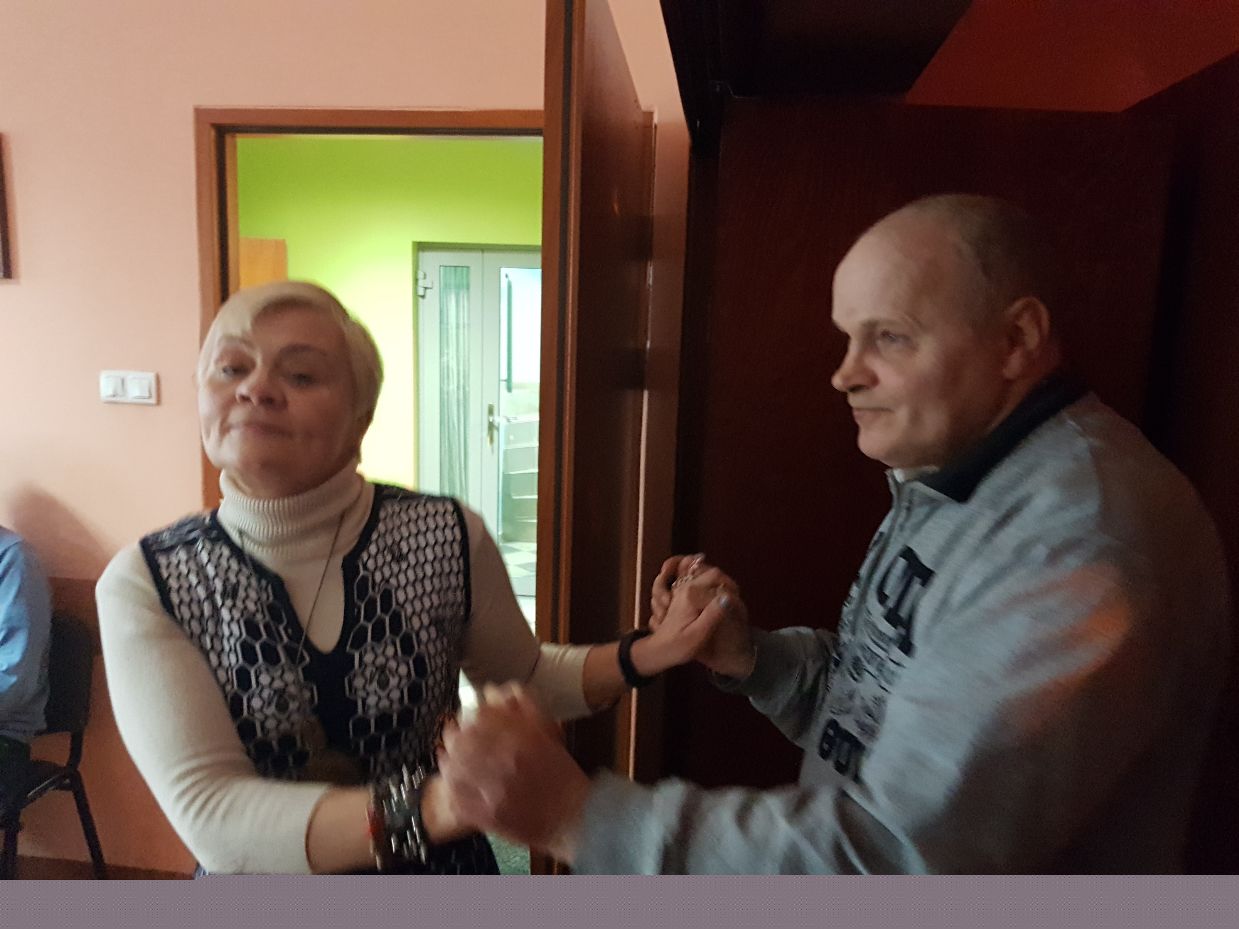 Kobieta i mężczyzna tańczą trzymając się za ręce.