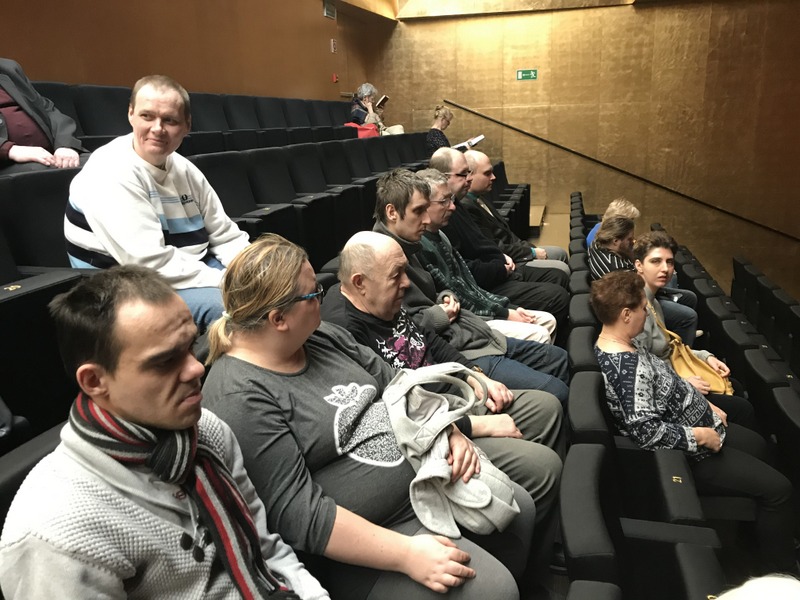 Kobiety i mężczyźni siedzący na fotelach w Filharmonii Szczecińskiej.