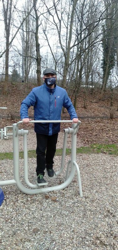 Mężczyzna ćwiczy na przyrządzie sportowym w fit parku.