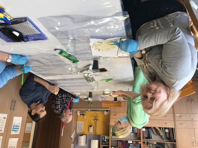 Dwie kobiety i dwóch mężczyzn wykonują prace z gliny.