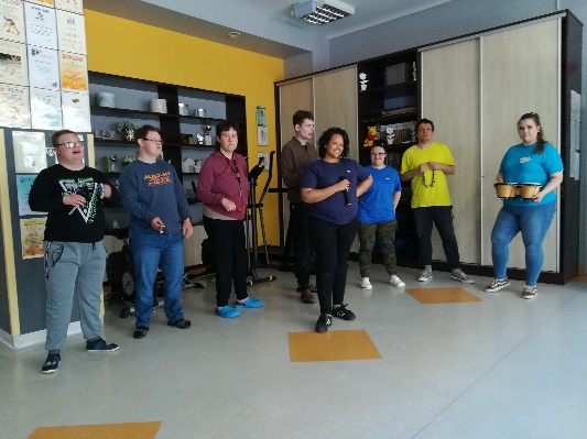 Kobiety i mężczyźni pozują do zdjęcia ze sprzętem muzycznym