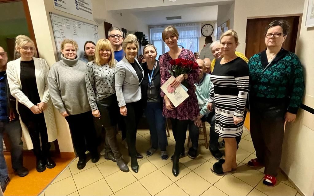 Grupa kobiet i mężczyzn pozuje do zdjęcia grupowego. 