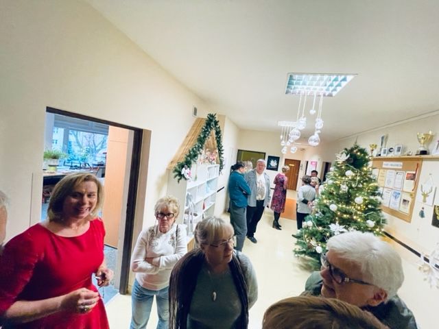 Grupa kobiet i mężczyzn pozuje do zdjęcia  na wspólnym spotkaniu rodzin i opiekunów.