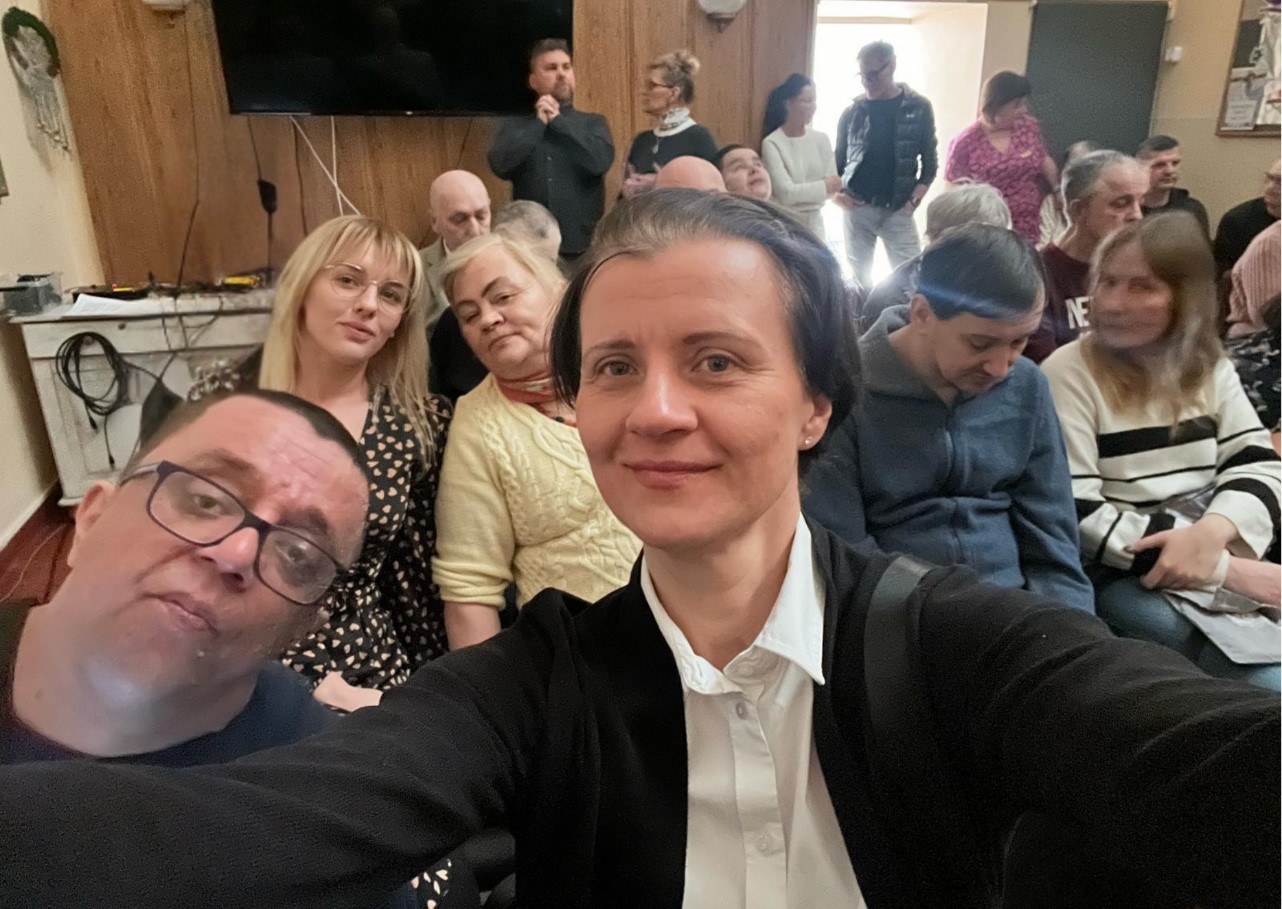 Grupa kobiet i mężczyzn pozuje do zdjęcia.