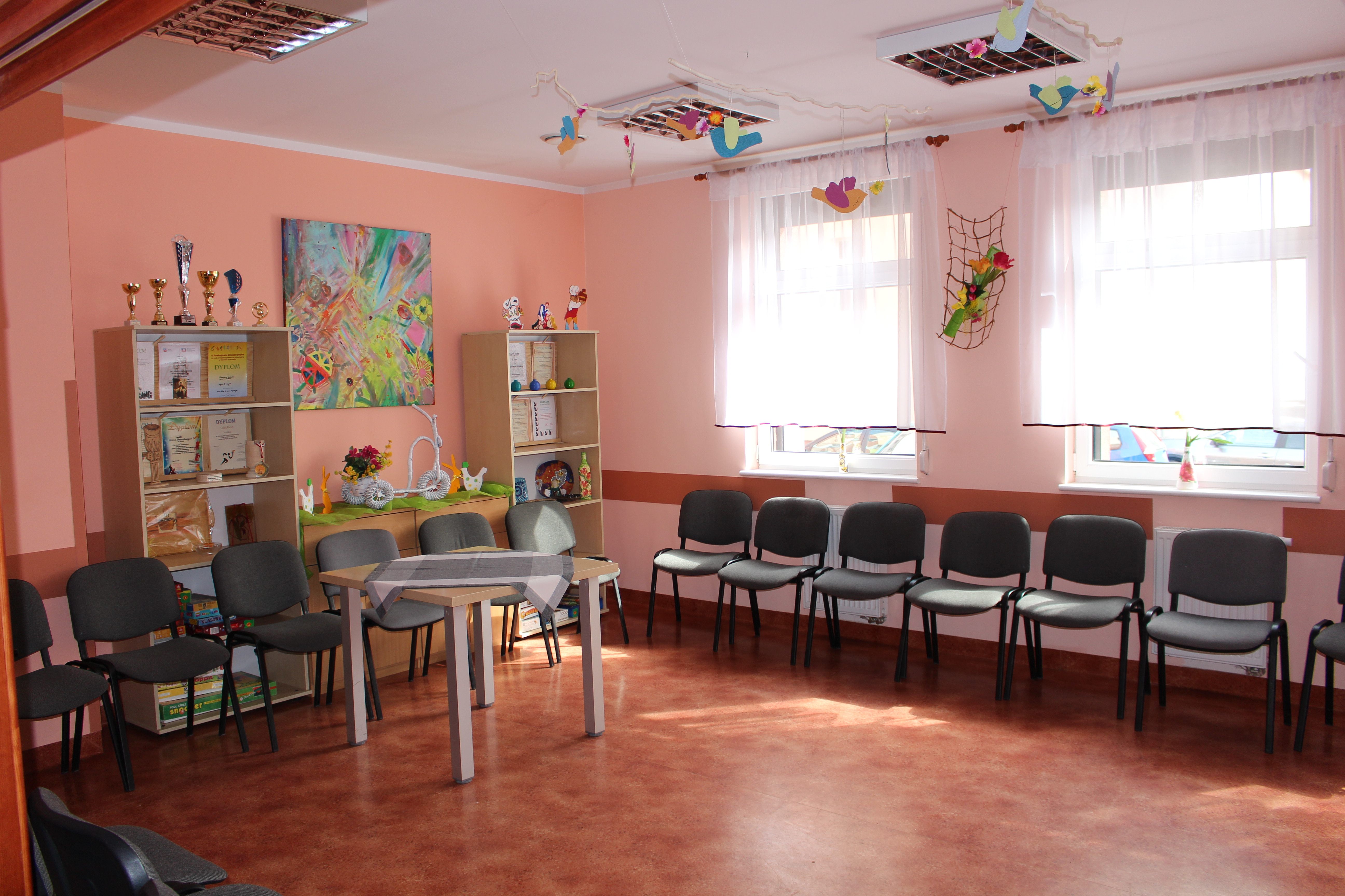 Sala spotkań z krzesłami oraz regałami.
