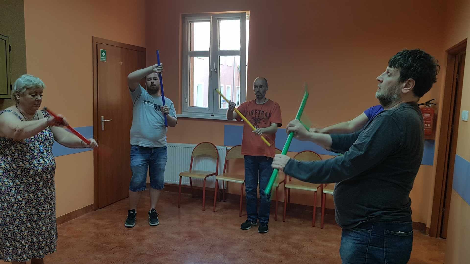 Ludzie stoją trzymają w rękach przyrządy do ćwiczeń