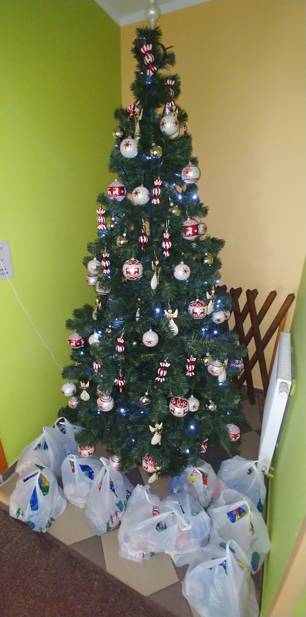 Przybrana choinka pod nią paczki świąteczne.