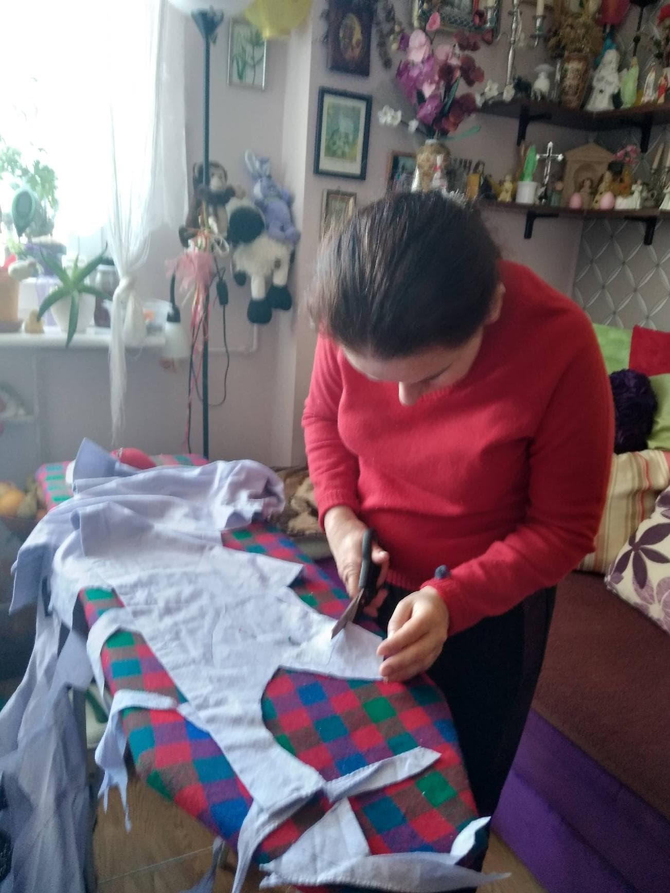 Kobieta pochyla się z nożyczkami nad materiałem .