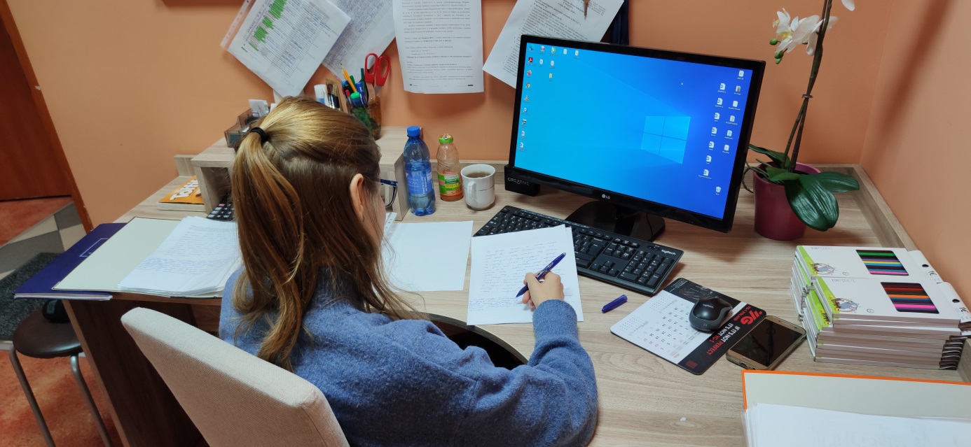 Kobieta siedzi przed monitorem komputera.