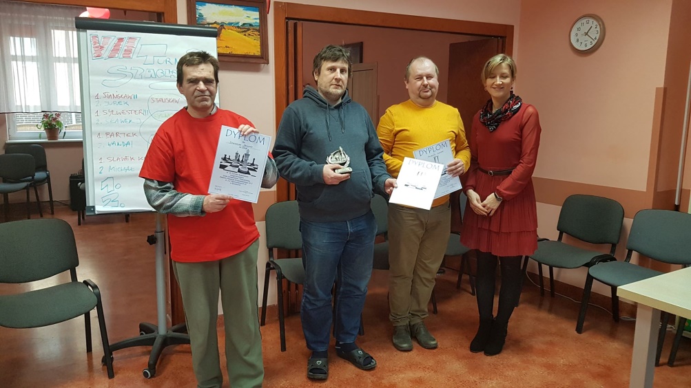 Trzech mężczyzn stoi z kobitą ,dwóch trzyma dyplomy.