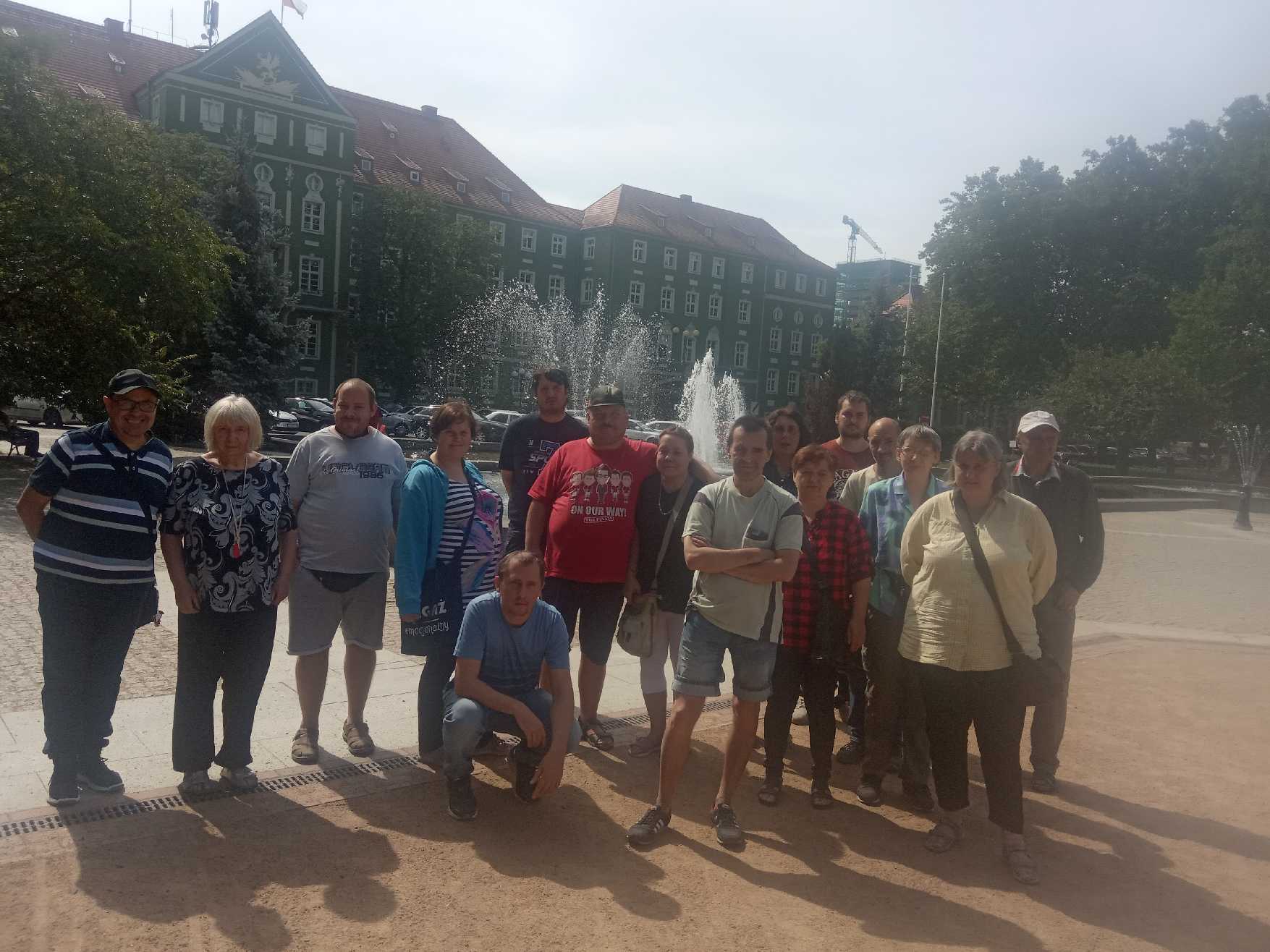 Grupa osób stoi przy fontannie.