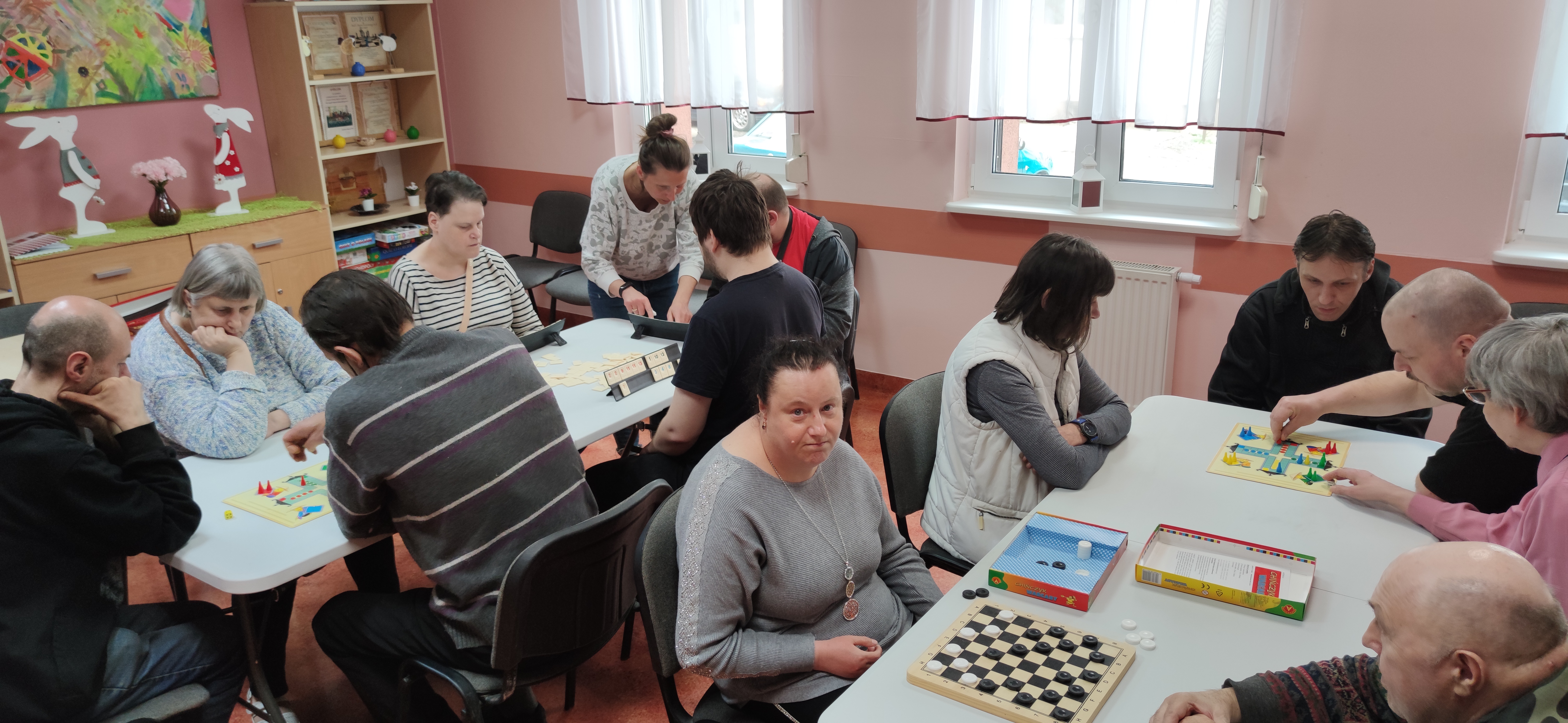 Grupa osób gra przy stołach w gry.