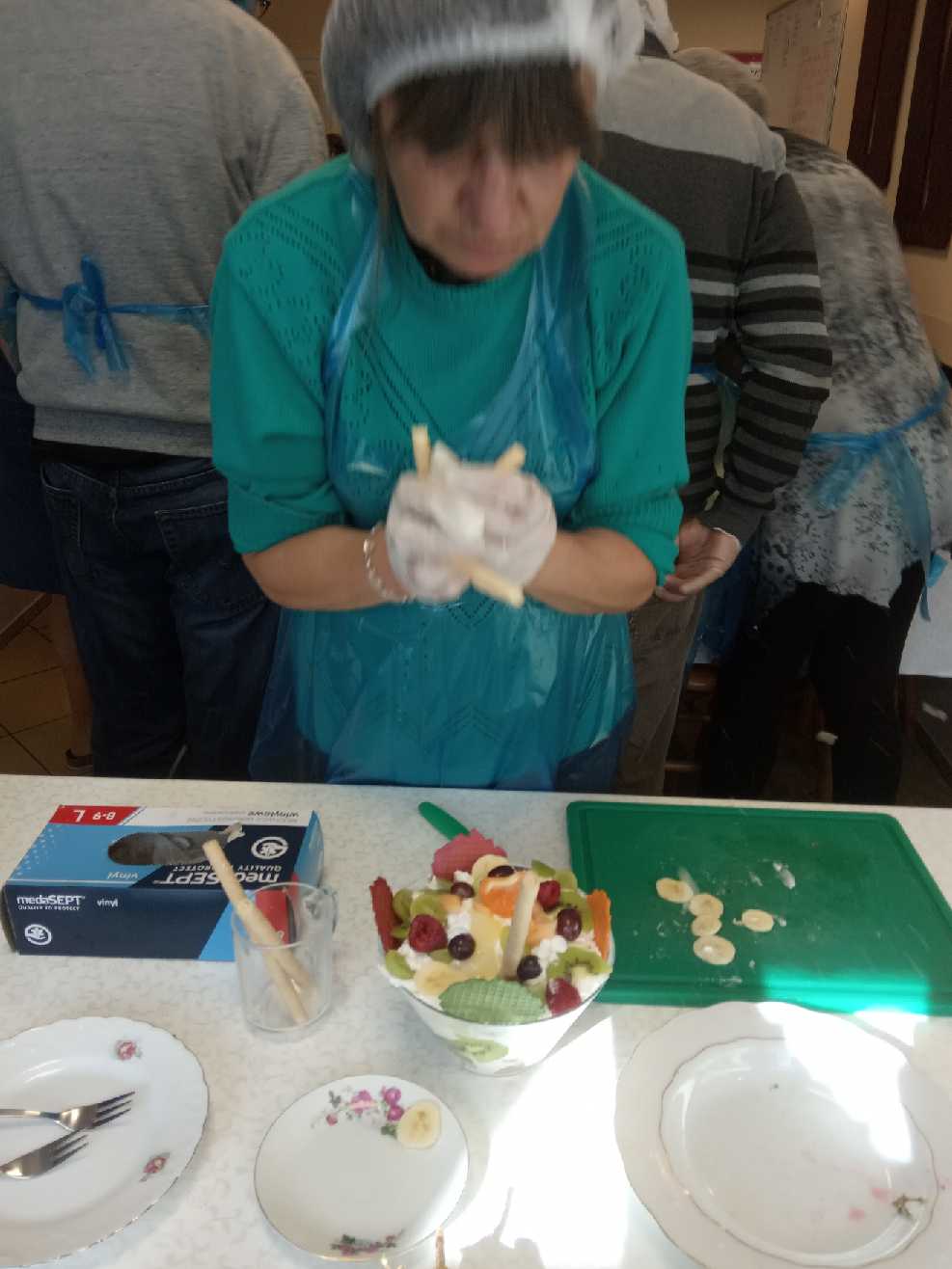 Kobieta lepi pierogi w kuchni.