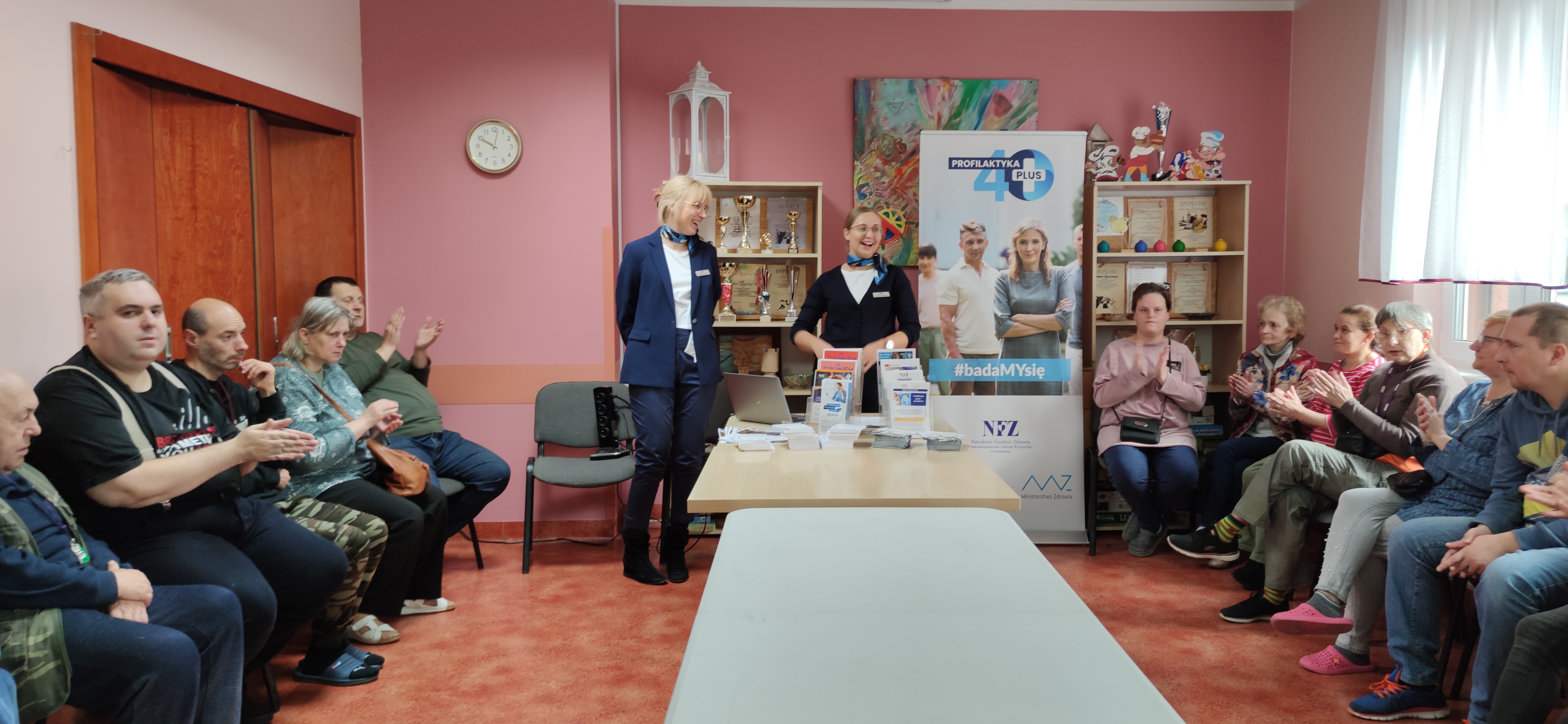Panie z NFZ przemawiają do siedzących uczestników.