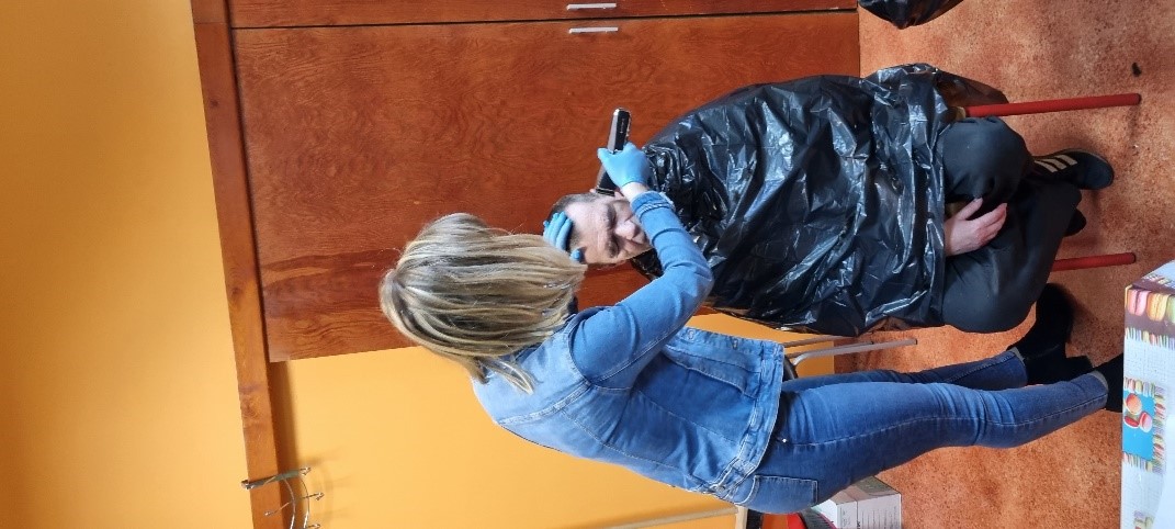 Kobieta ścinająca włosy mężczyźnie.