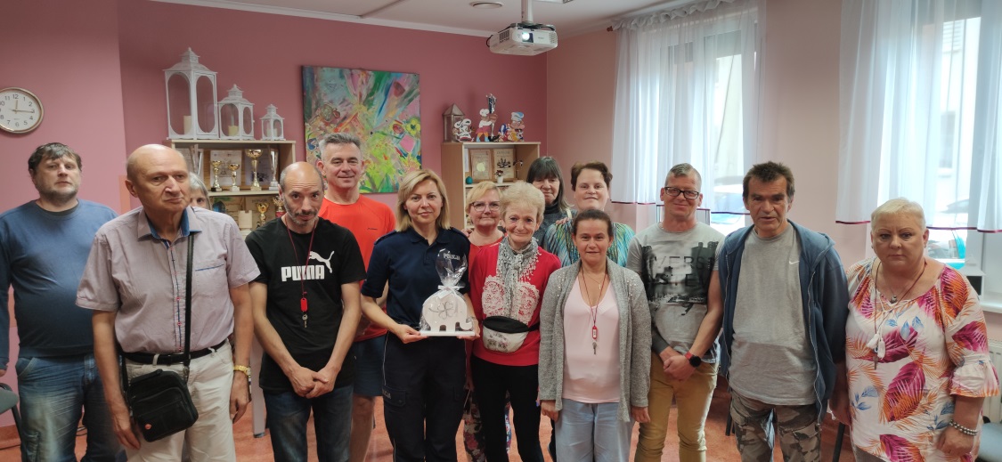 Grupa osób pozuje do zdjęcia z policjantką.