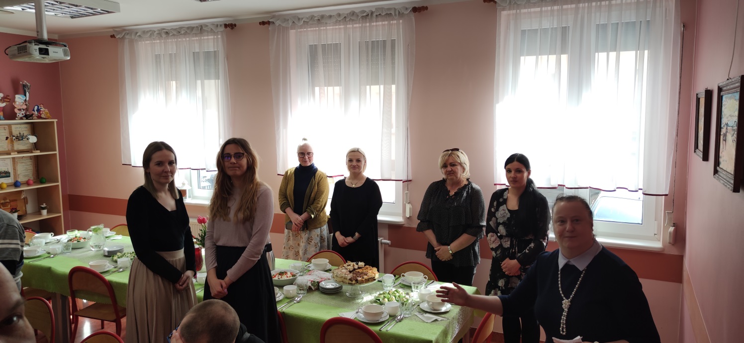 Grupa osób przy śiątecznie udekorowanym stole.
