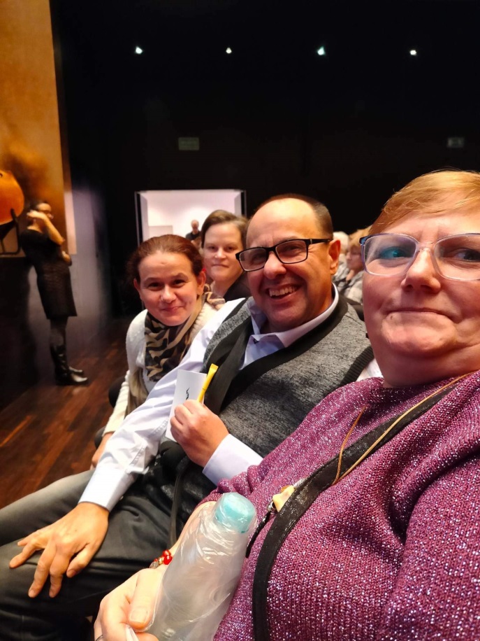 Grupa osób siedzi na widowni w filharmonii