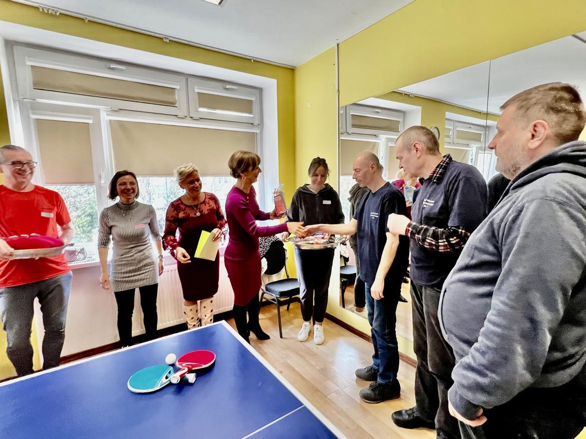 Grupa osób stoi do wręczenia dyplomów.