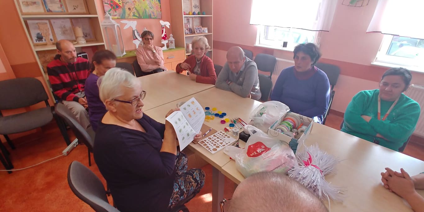 Ludzie siedzą przy stole ,na nim leżą kawałki papieru.