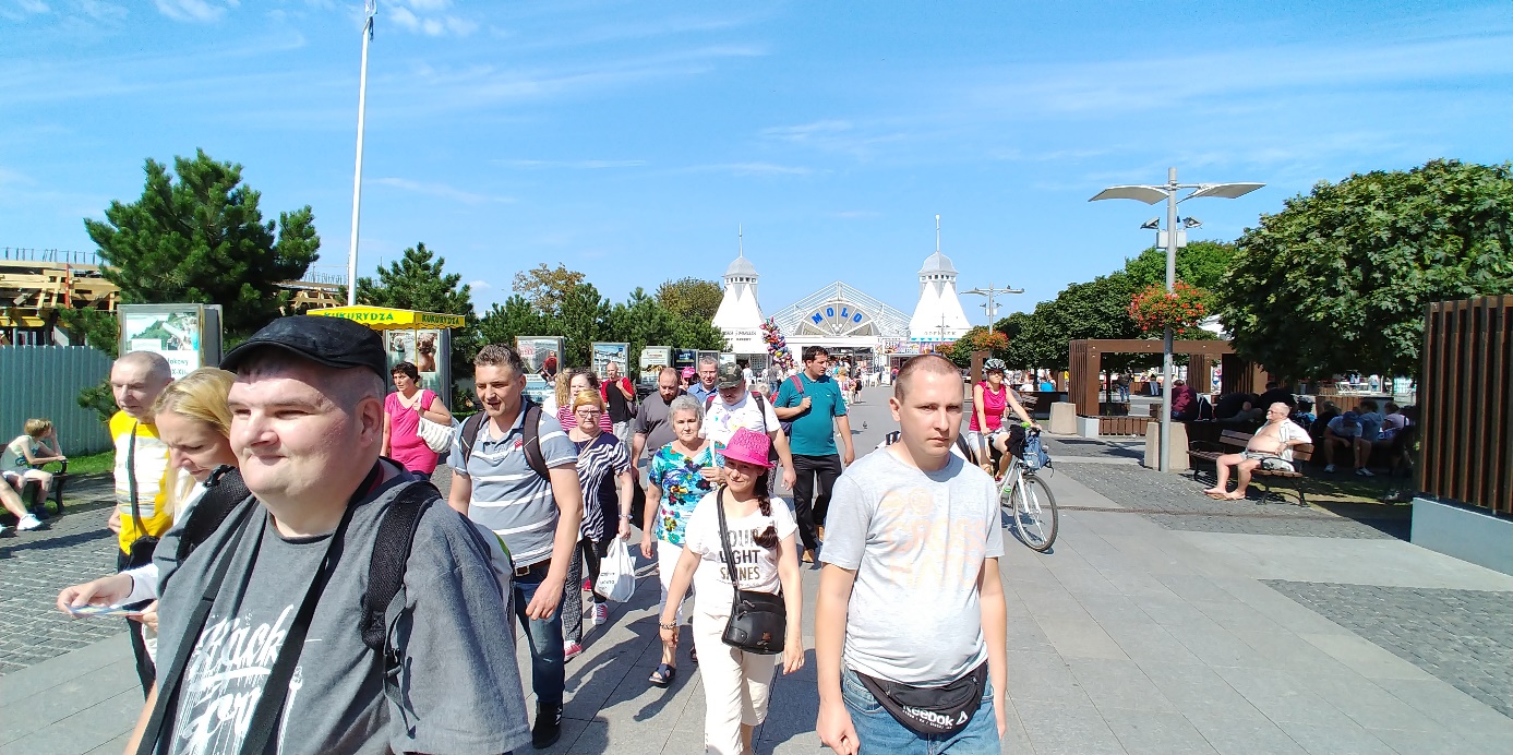 Ludzie idą promenadą.