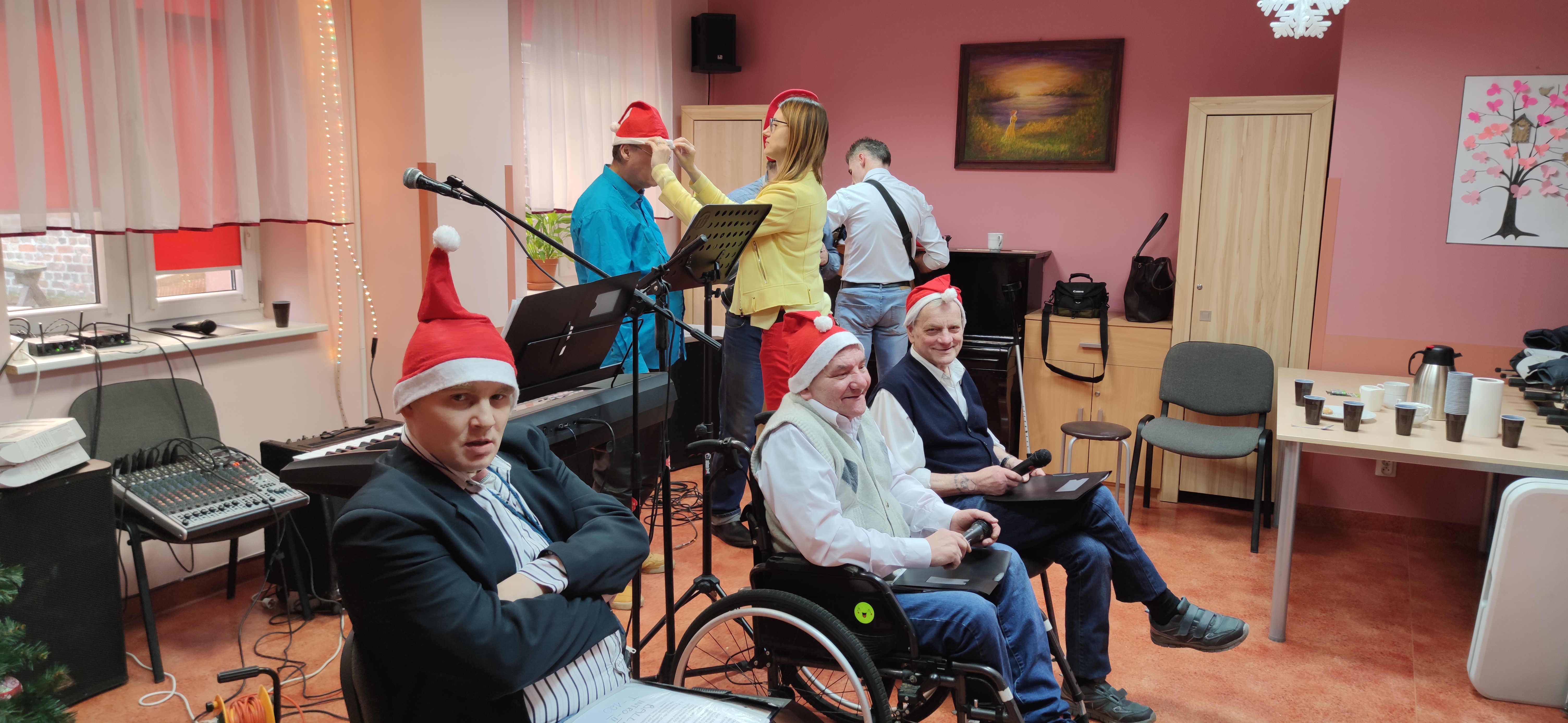 Grupa mężczyzn przy instrumentach siedzących na sali.