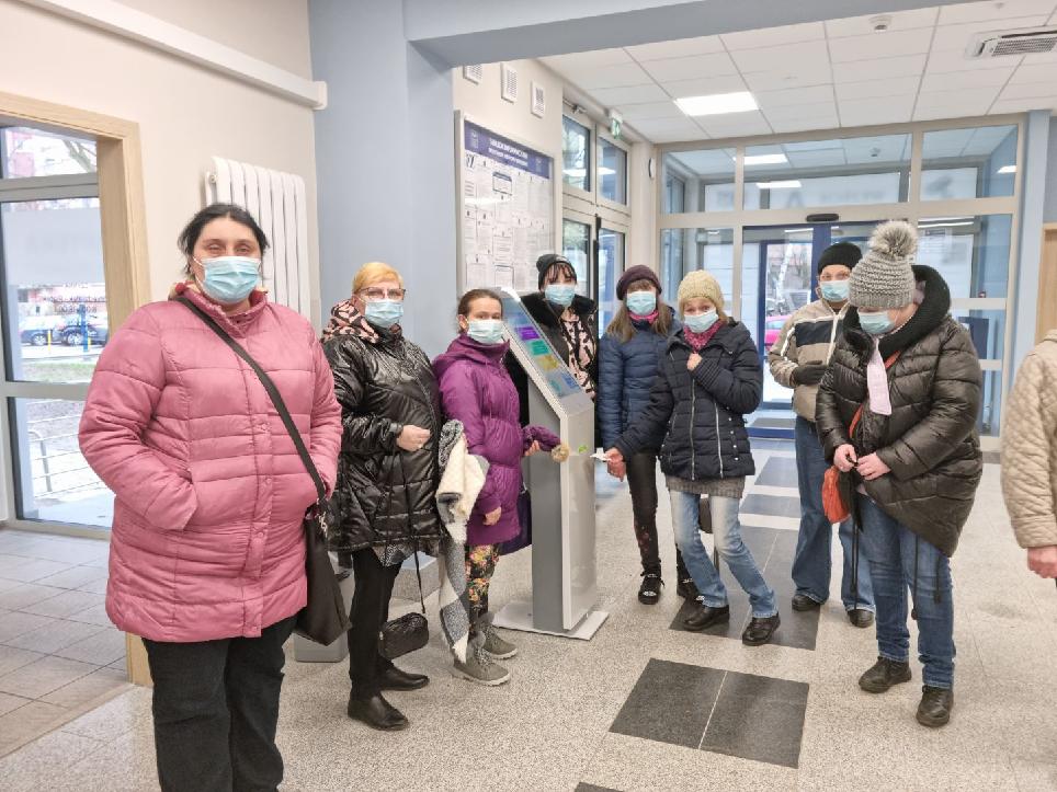 Grupa pań na korytarzu przychodni w maseczkach.