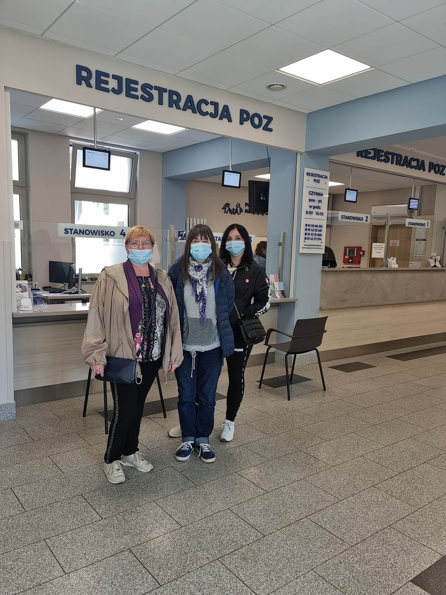 Kobiety stoją w maseczkach przed rejestracją.