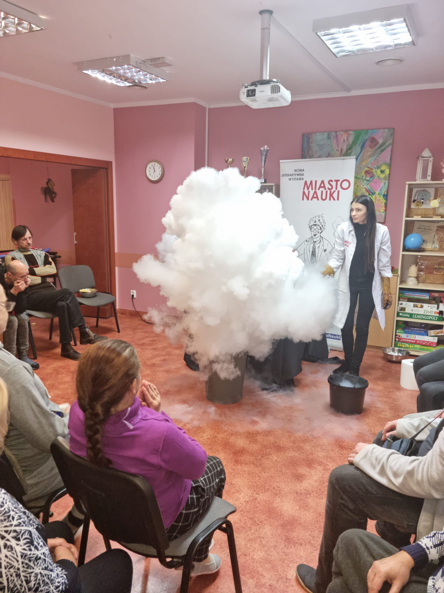 Chmura dymu z eksperymentu ,kilka osób patrzy na eksperyment.