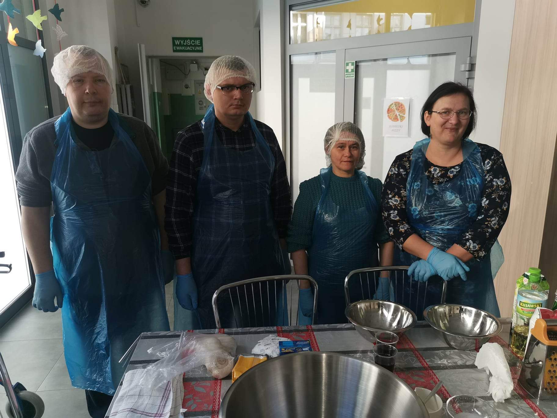 Cztery osoby stoją przy stole.