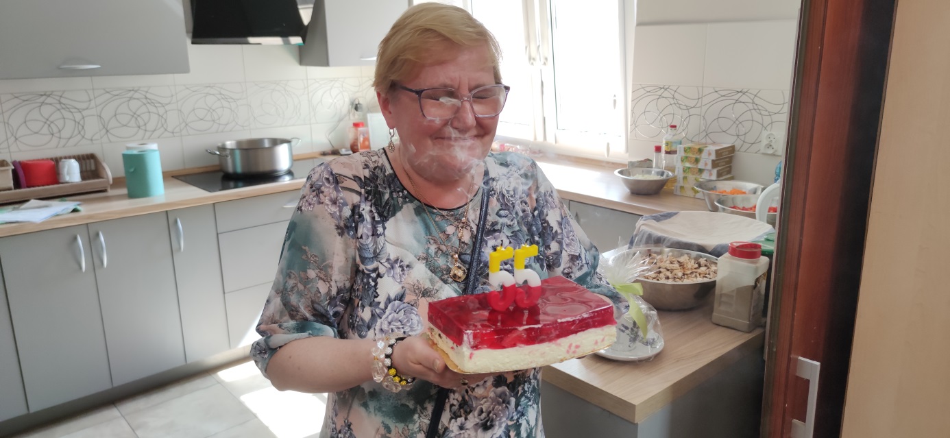 Kobieta gasi świeczki na torcie.