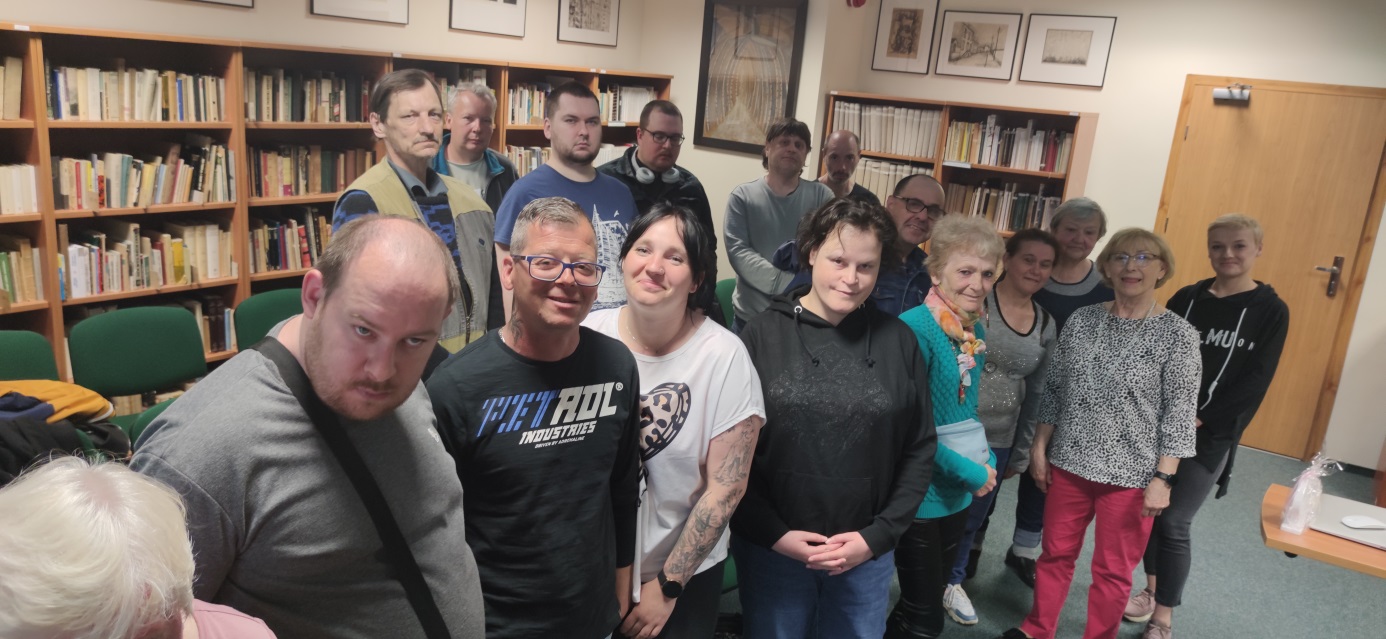 Grupa osób w Książnicy Pomorskiej pozuje do zdjęcia z prelegentką.