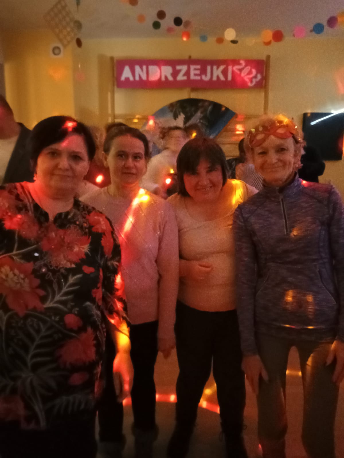 Trzy panie na tle bawiących się ludzi.
