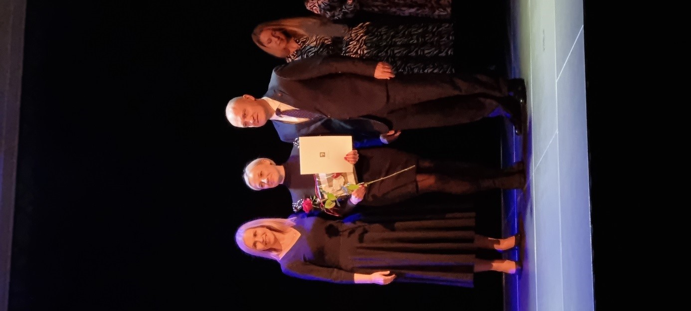 Stojące na scenie dwie kobiety i jeden mężczyzna.