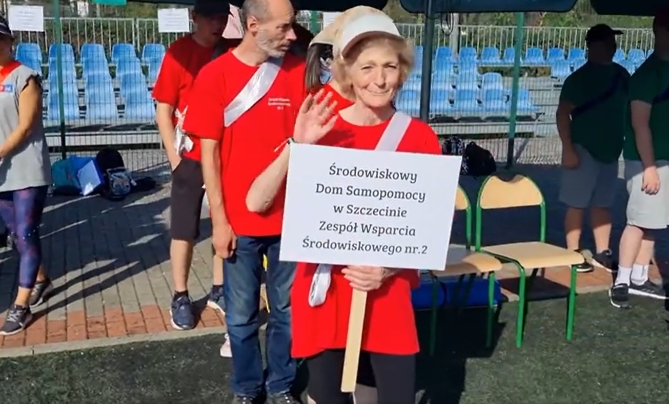 Kobieta trzyma tablicę z napisem ŚDS.
