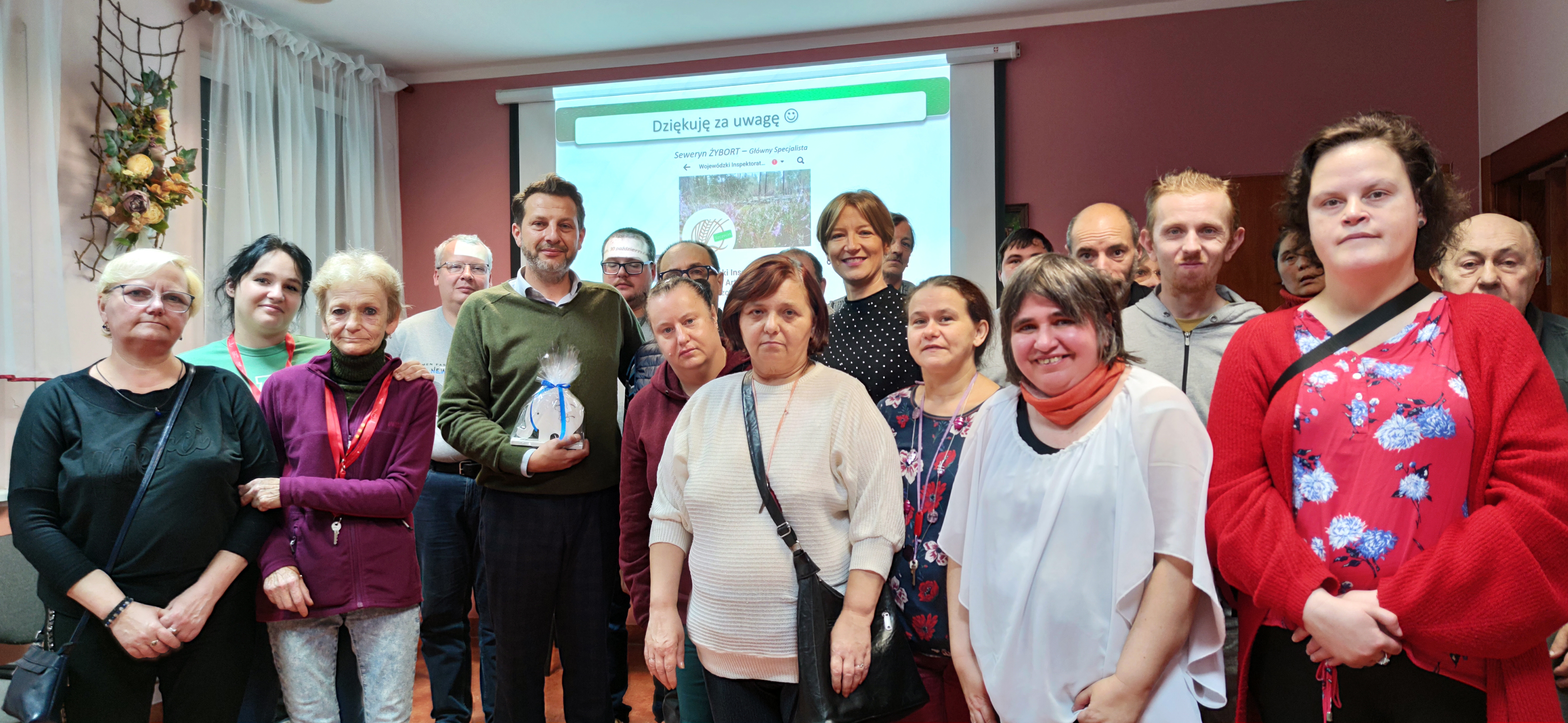 Grupa osób stoi z inspektorem pozując do zdjęcia.