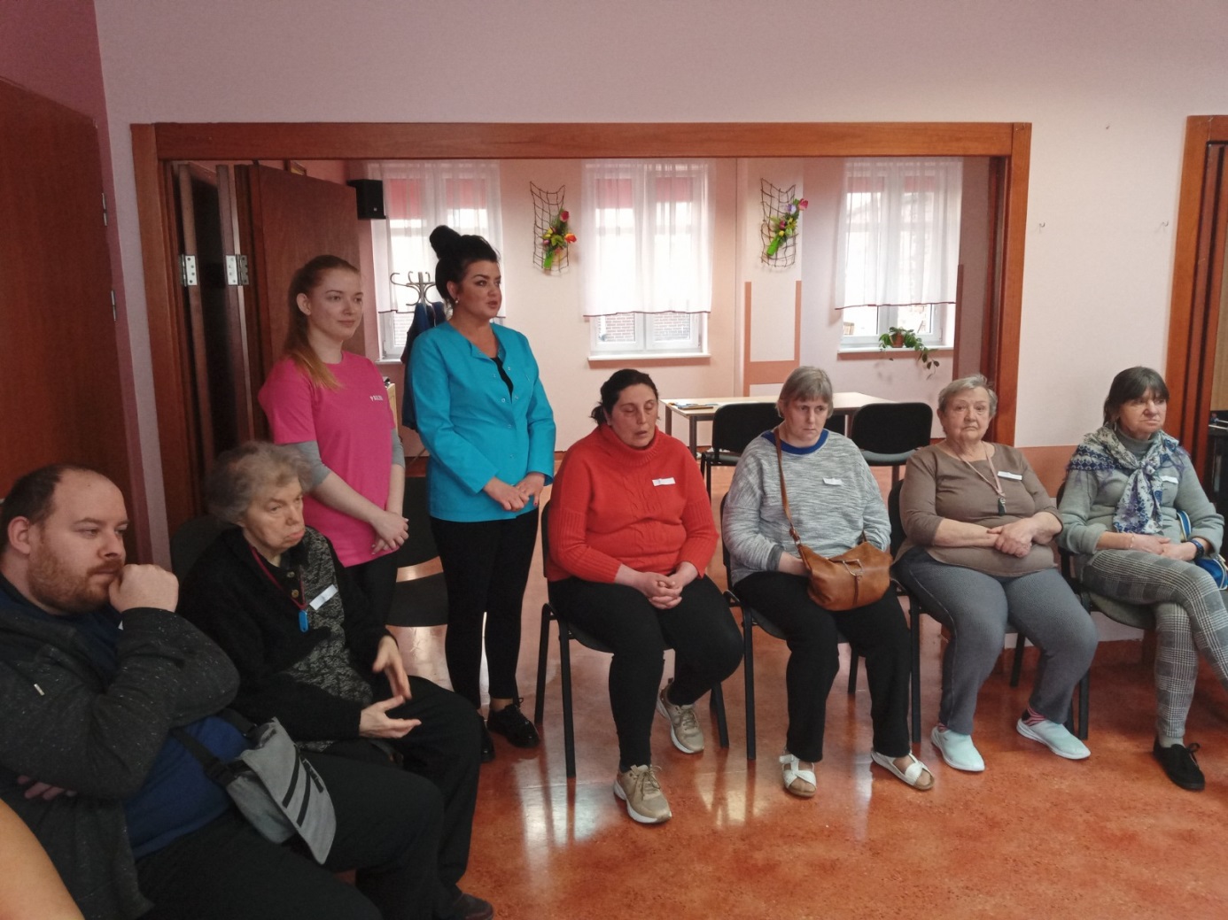 Dwie kobiety przemawiają do siedzących.