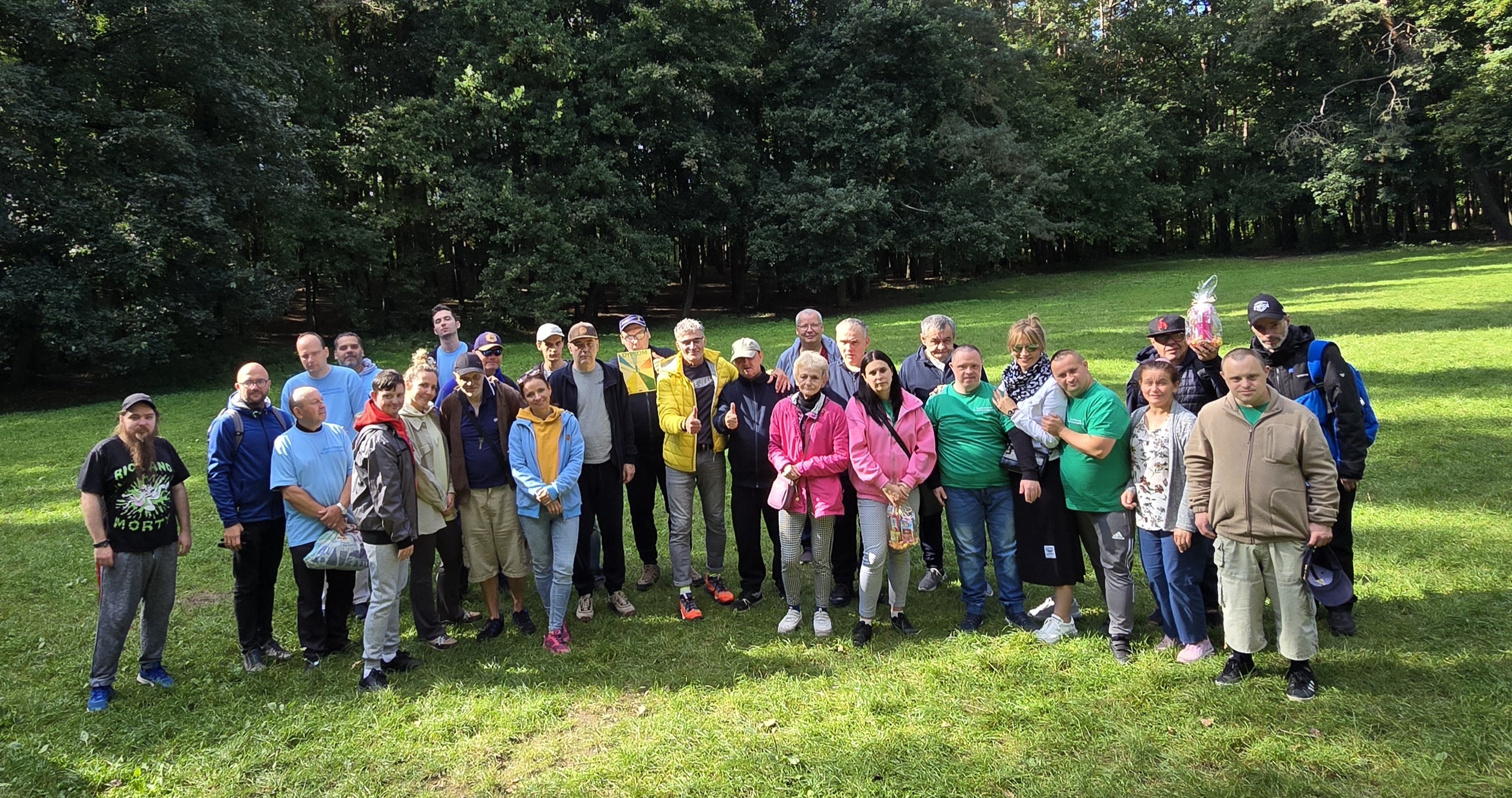 Grupa uczestników pozuje z trofeami do zdjęcia pamiątkowego.