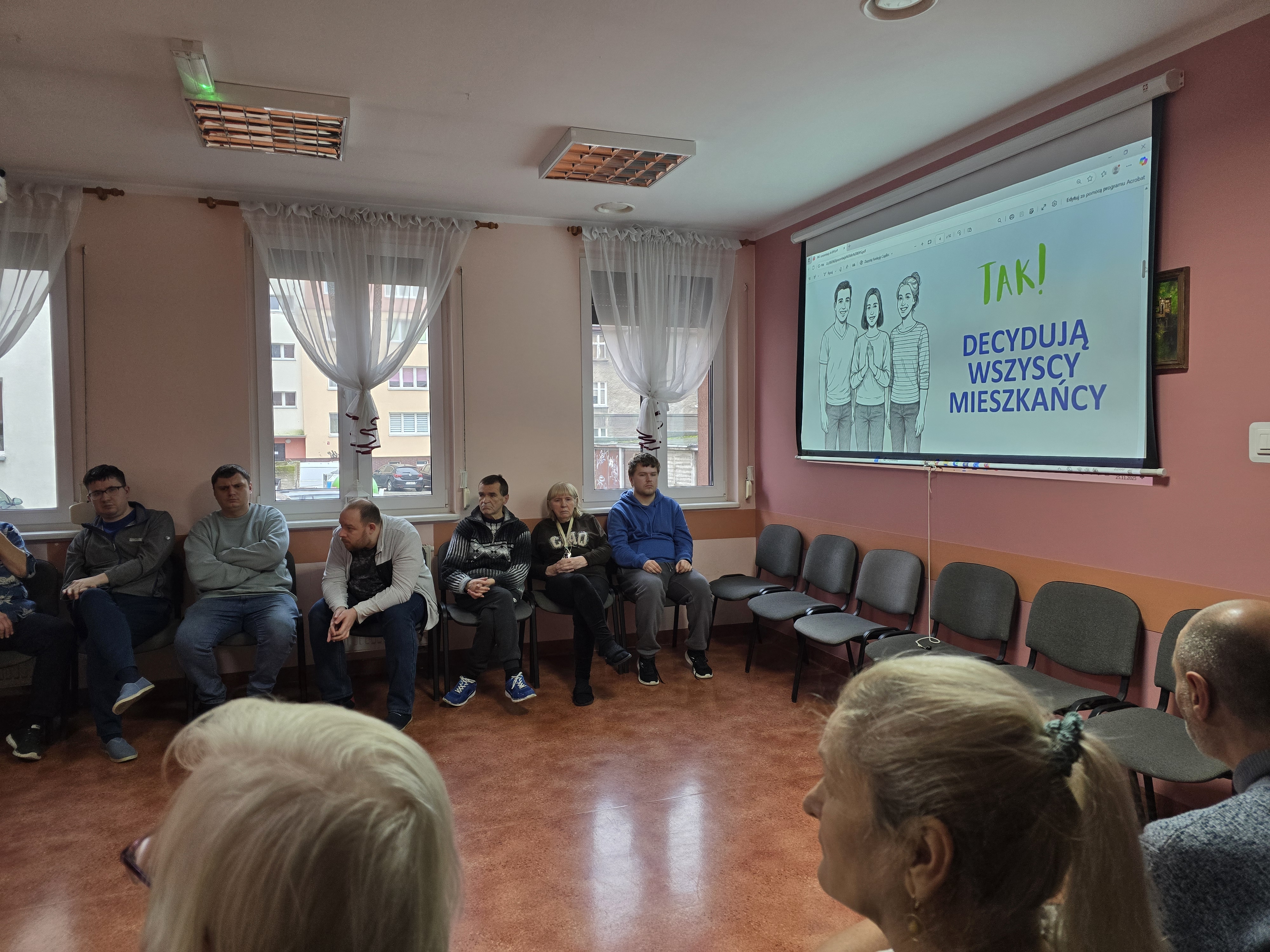 Na ekranie w sali z rzutnikiem widać napis o budżecie obywatelskim.