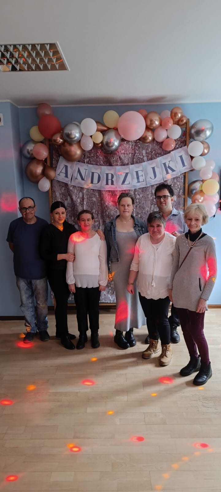 Grupa osób na zabawie tanecznej pozuje do zdjęcia.